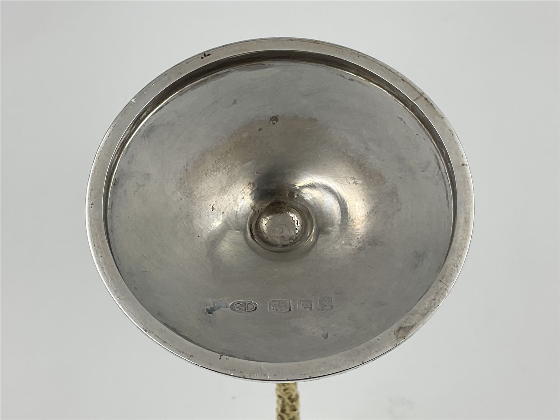 Pair of modern silver candlesticks by Stuart Devlin, the tapering parcel gilt stems with signature textured detailing, each supporting a fluted candle holder and upon a spreading circular foot, hallmarked Stuart Devlin, London 1973, H25cm