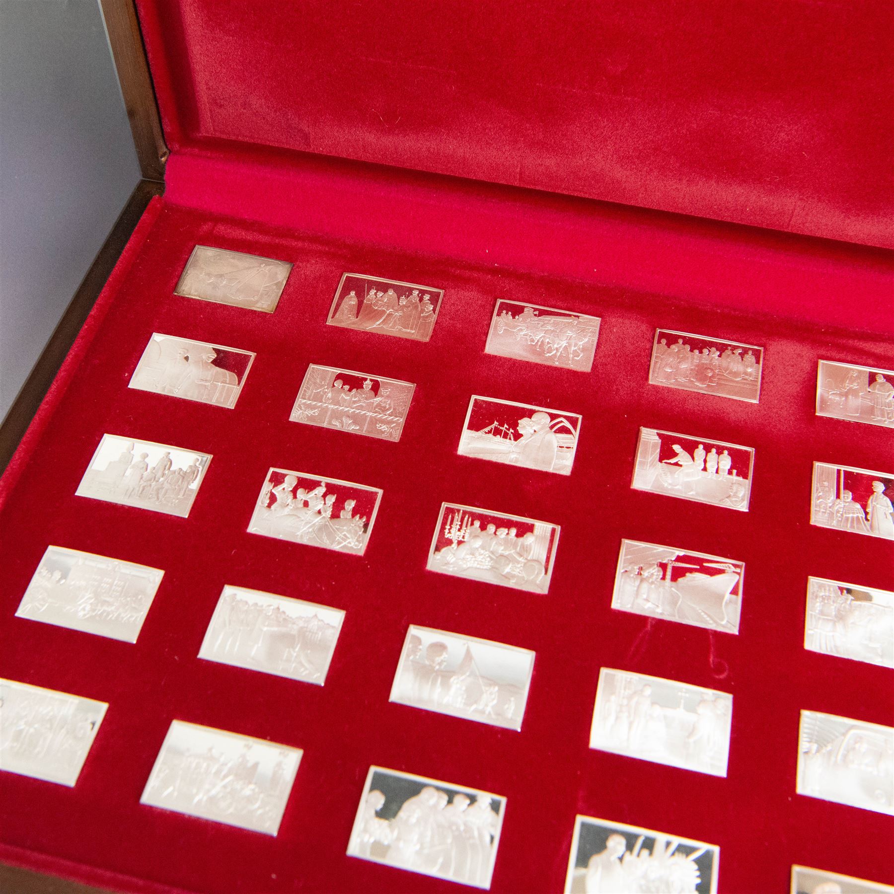 Elizabeth Our Queen silver ingots collection, twenty-five rectangular ingots each decorated in relief with a Royal scene, hallmarked John Pinches Ltd, London 1976, in wooden presentation case with information booklet