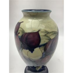 Moorcroft Wisteria pattern vase, circa 1916, lender baluster form, decorated with foliage, in tones of creams and purples, on a blue ground, with painted and impressed sign beneath, H23cm