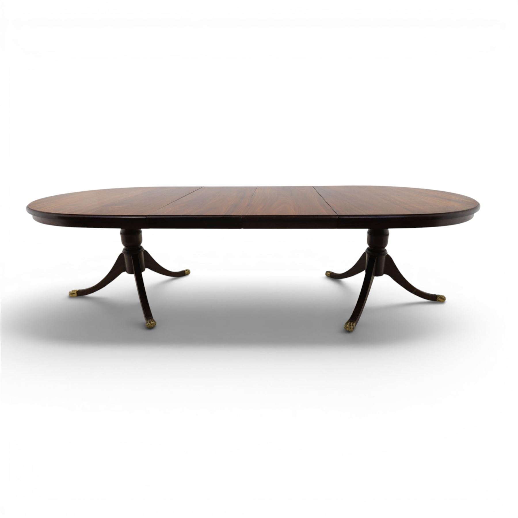 Regency design mahogany extending twin pedestal dining table with two additional leaves, raised on splayed supports terminating brass paw feet
Extends to 268cm
