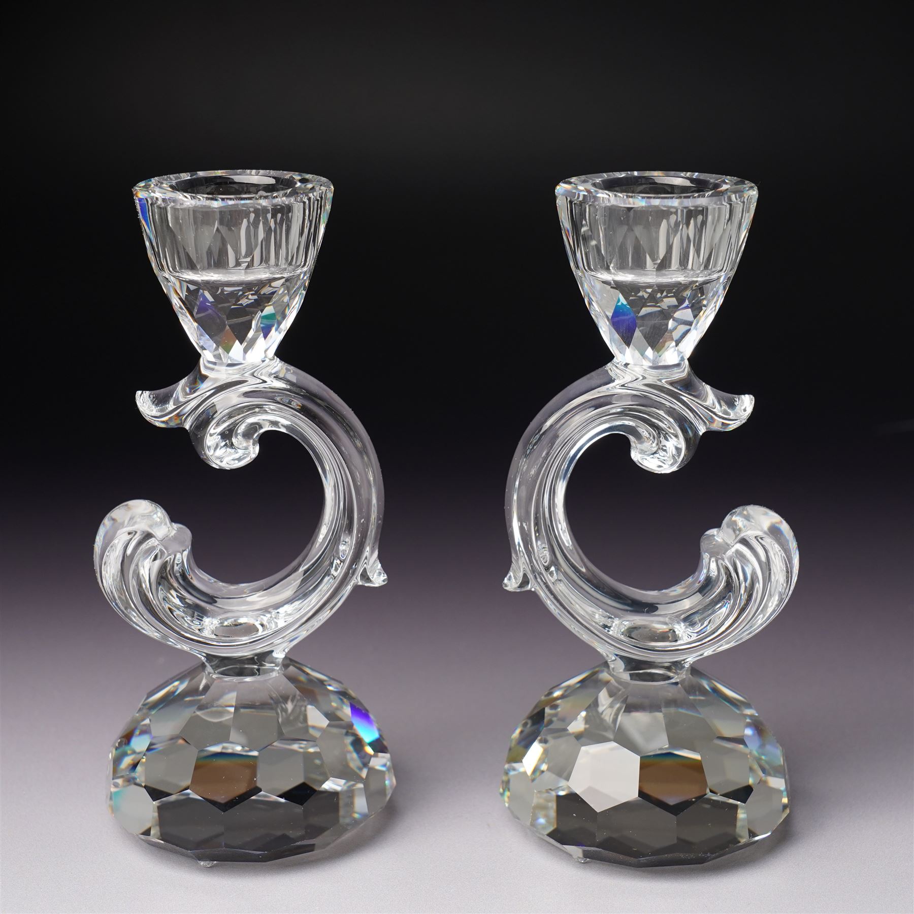Pair of Swarovski Crystal candlesticks, boxed, together with two paperweights in the form of pineapples with gilt mounts, a large and small example, boxed (4)