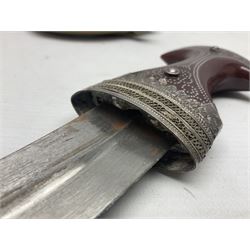 Omani Khanjar dagger, the 12.5cm curved blade with pronounced medial rib to either side, waisted horn style hilt with dome shaped pommel and inlaid pique work; in an intricately filigree decorated white metal scabbard with rings woven into the belt mount L25cm overall