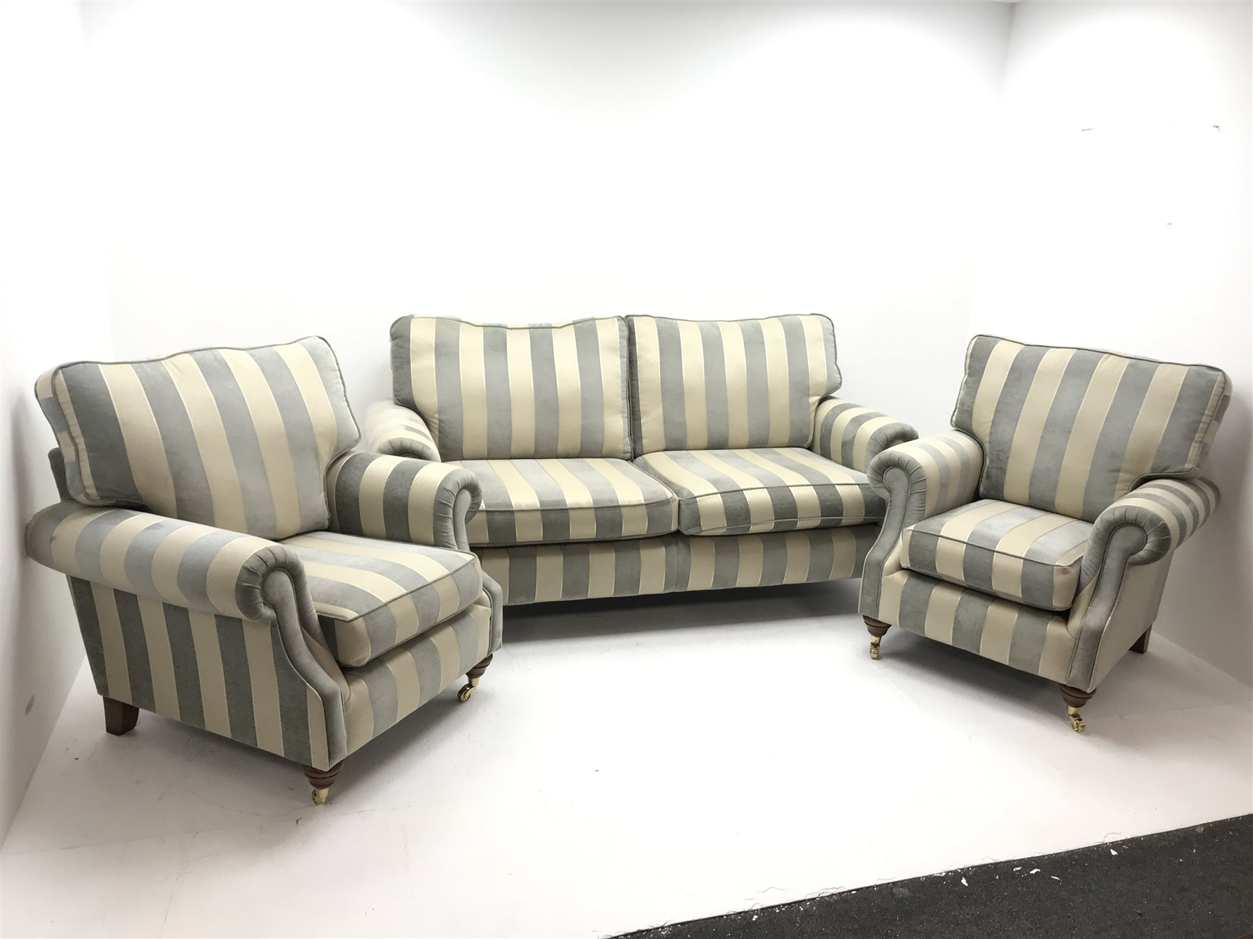 Alstons two seat Amberley sofa upholstered in grey and pale gold stripes, turned supports on castors (W195cm) and two matching armchairs (W92cm)