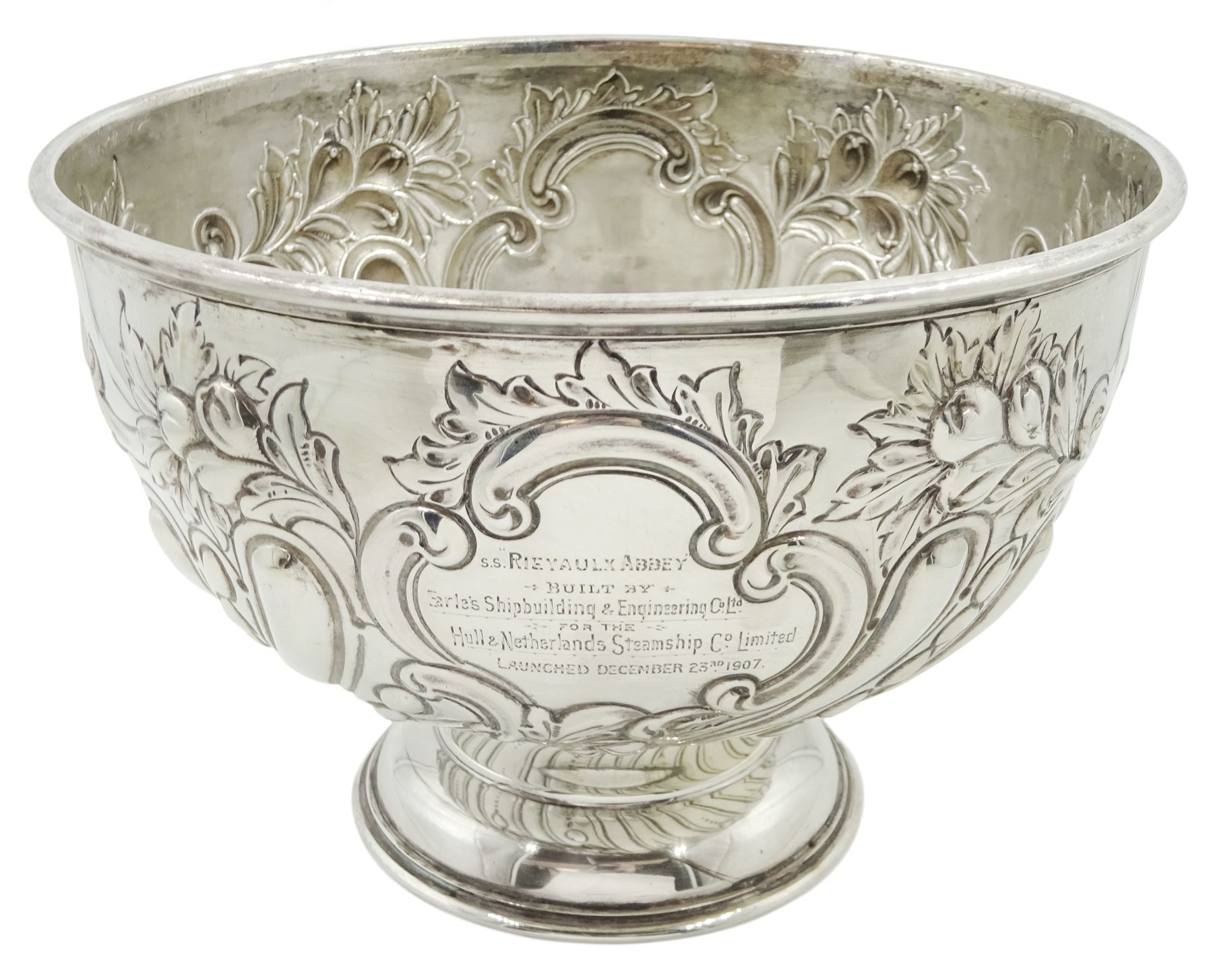 Edwardian silver rose bowl, the part fluted bowl embossed with acanthus leaves, flower heads and C scrolls and personally engraving 'S.S Rievaulx Abbey - Built By - Earle's Shipbuilding & Engineering Co Ltd - For The - Hull & Netherlands Steamship Co. Limited Launched December 23rd 1907', upon a spreading circular foot, hallmarked F Boyton & Co, London 1905, H14.5cm, D20.5cm, approximate weight 17.34 ozt (539.6 grams)