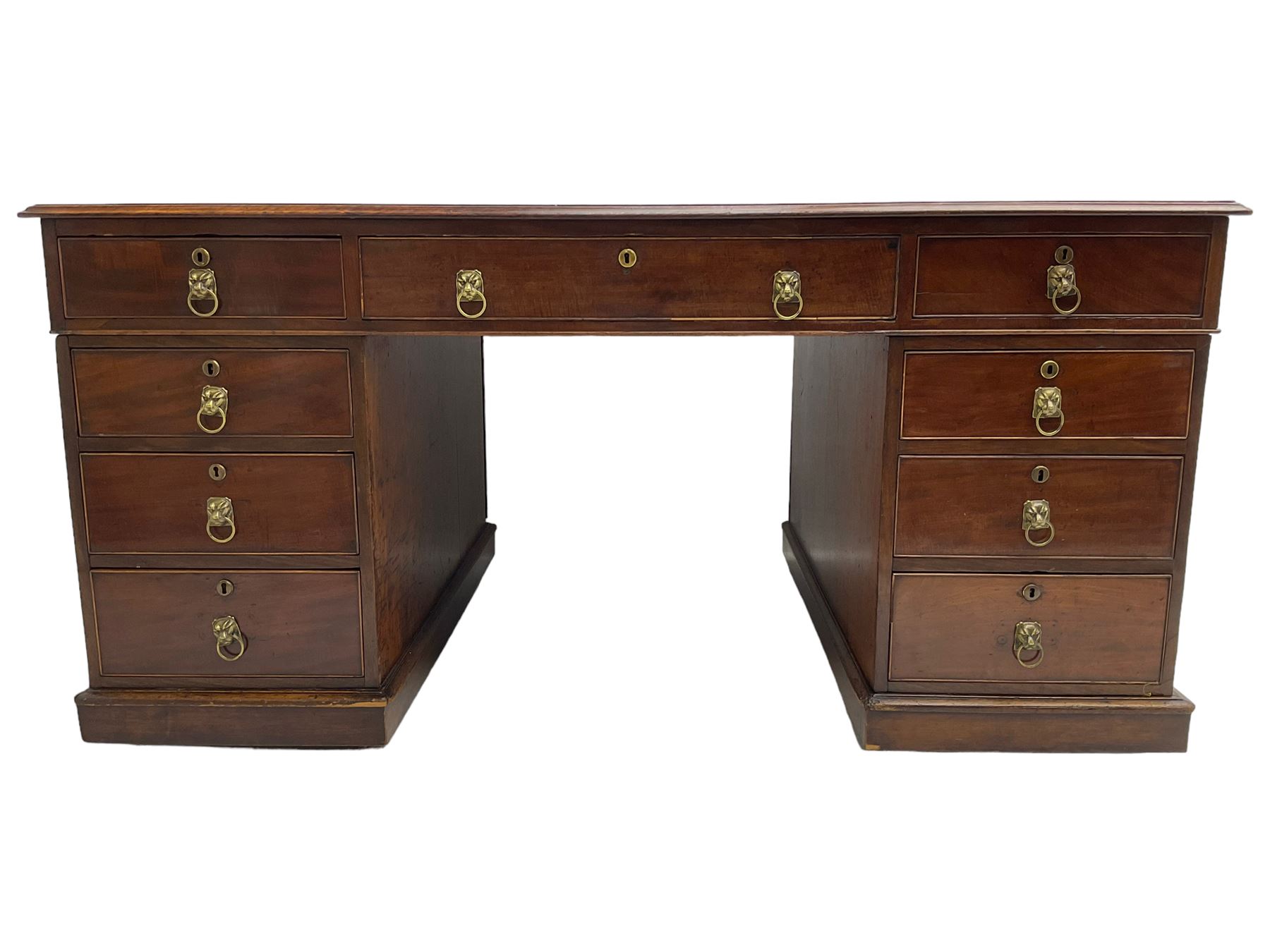 George III mahogany twin pedestal partners desk, rectangular top with moulded edge and an inset green tooled leather writing surface with Greek key design border, fitted with three cock-beaded frieze drawers to each side, each pedestal with three graduating drawers with an opposing panelled cupboard enclosing a single shelf, the facias fitted with brass lion mask plates with ring handles, the lower moulded edge over a plinth base and castors, London furniture dealers label to interior of drawer inscribed 'J. Webb, Office Furniture 323, Gray's Inn Road, King's Cross'  H75cm  W153cm  D97cm