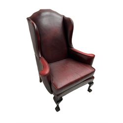 Georgian style wingback armchair, upholstered in red leather with stud work, curved arms with scrolled terminals, on ball and claw front feet