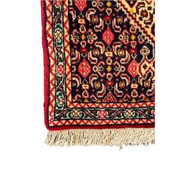 North West Persian Senneh indigo and crimson ground runner, the Herati decorated field with five interconnected lozenges, triple band border with repeating flower head motifs 