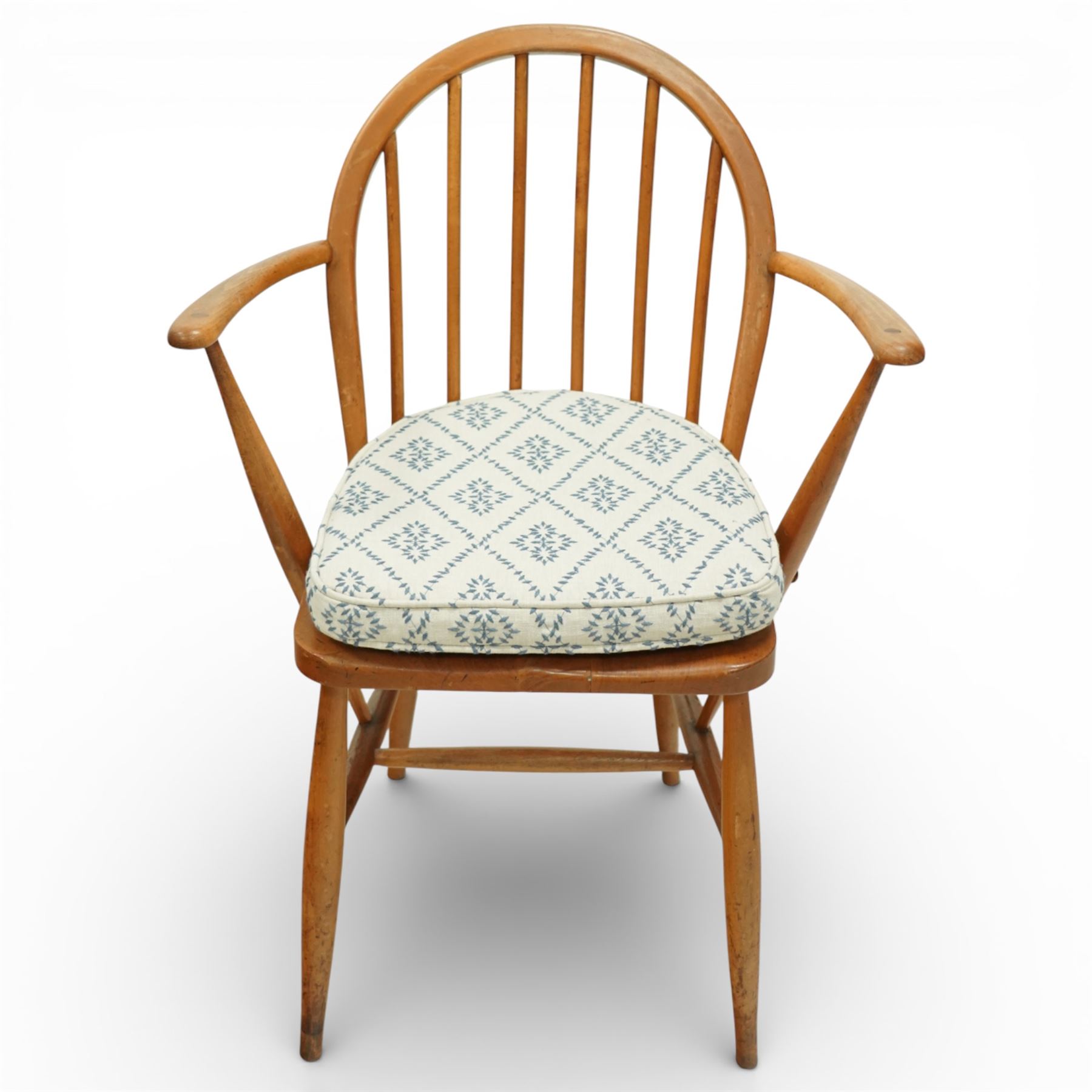 Ercol - elm dining chairs, a set of five comprising four side chairs and one '370' armchair, all with hoop backs formed with slender spindle splats, shaped solid elm seats, the armchair with curved out-swept arms, raised on splayed turned supports united by stretchers