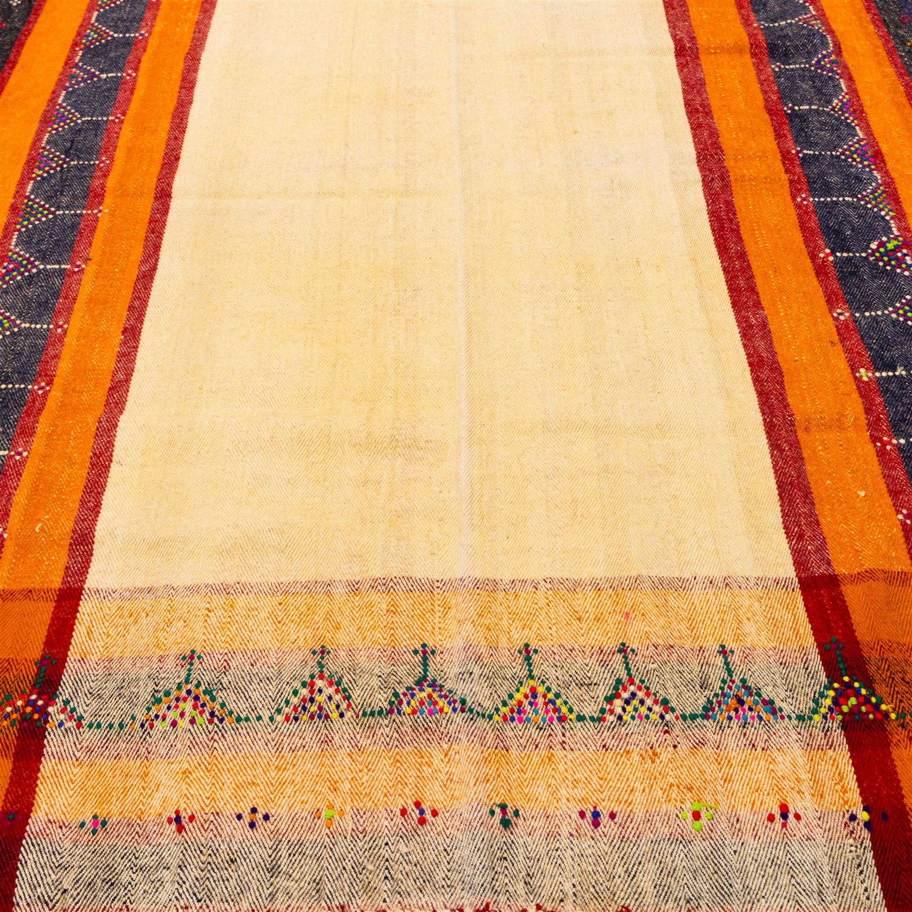 South West Persian Jajim kilim, central ivory field flanked by vertical bands of terracotta orange and dark brown decorated with simple geometric tribal motifs with raised wool pile details, edges finished with small coloured tassels 