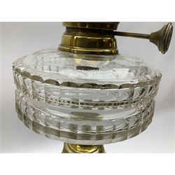 Victorian brass oil lamp, the square stepped base leading to a Corinthian column supporting a part slice cut clear glass reservoir, burner, clear glass chimney and foliate etched glass shade with amber rim, overall H80cm
