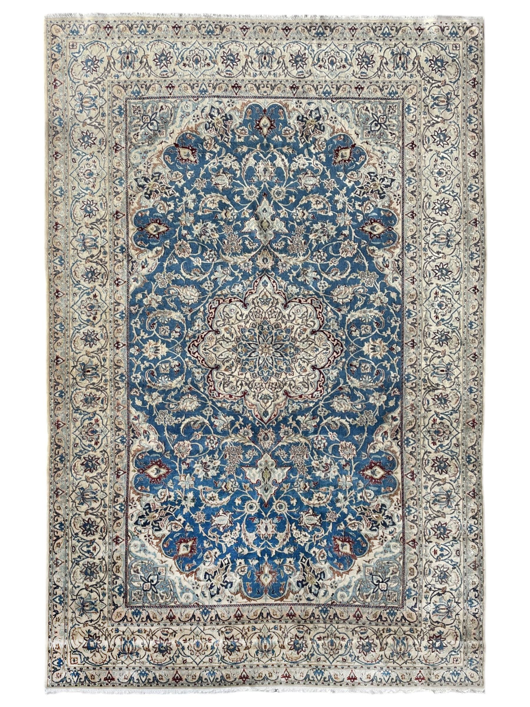 Persian Nain blue and ivory ground rug, wool with silk inlay, overall arabesque design, central medallion surrounded by interlacing and scrolled leafy branches and palmettes, the scrolling border decorated with stylised plant motifs, within guard stripes