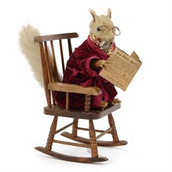 Anthropomorphic Taxidermy: Red squirrel (Sciurus vulgaris), dressed in a velvet dressing gown upon a rocking chair reading a newspaper from 1936, H28cm