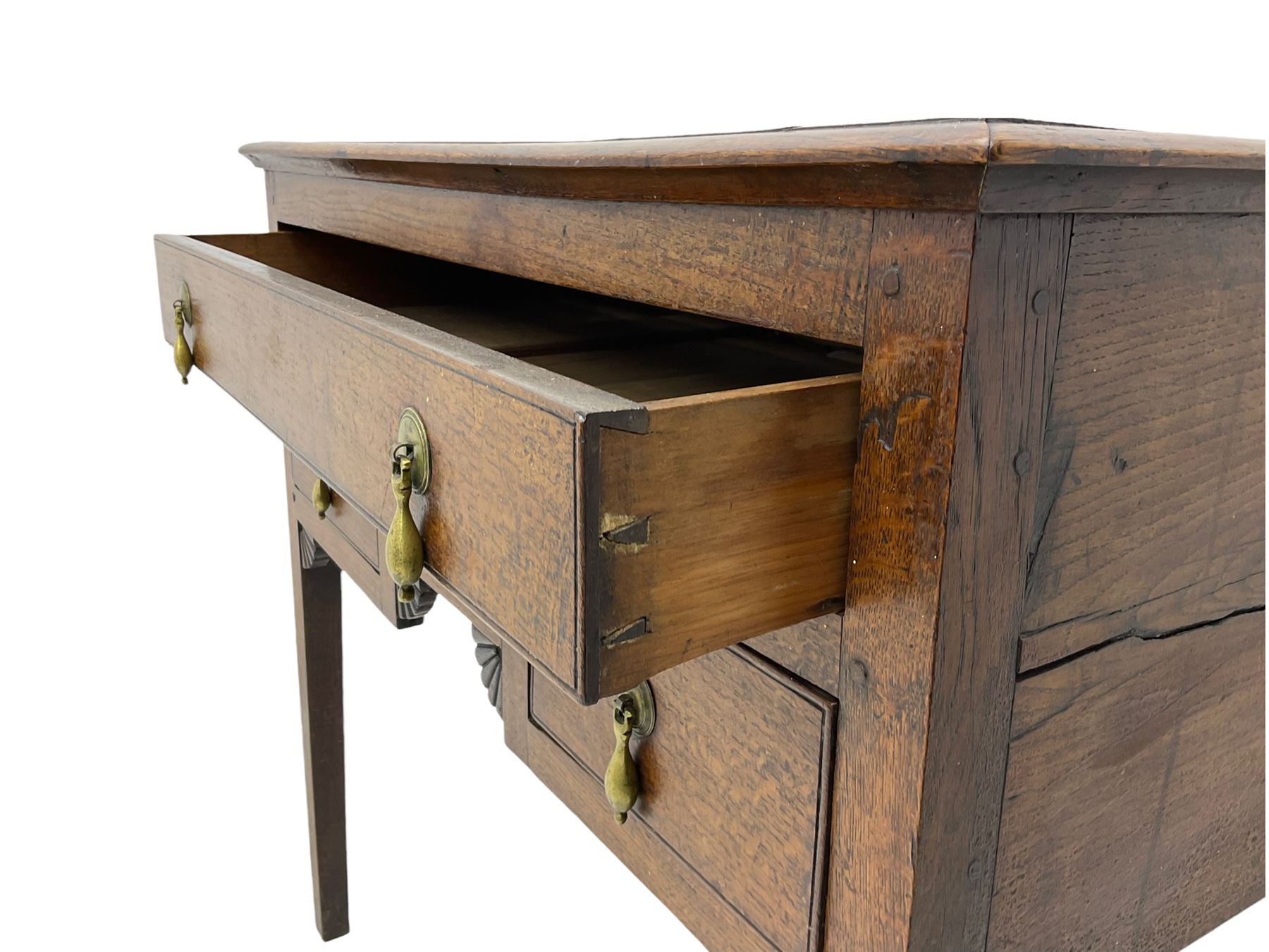18th century Welsh oak lowboy, fitted with long drawer above three small drawers, square tapering supports, with fan carved corner brackets, circular plate and drop handles 