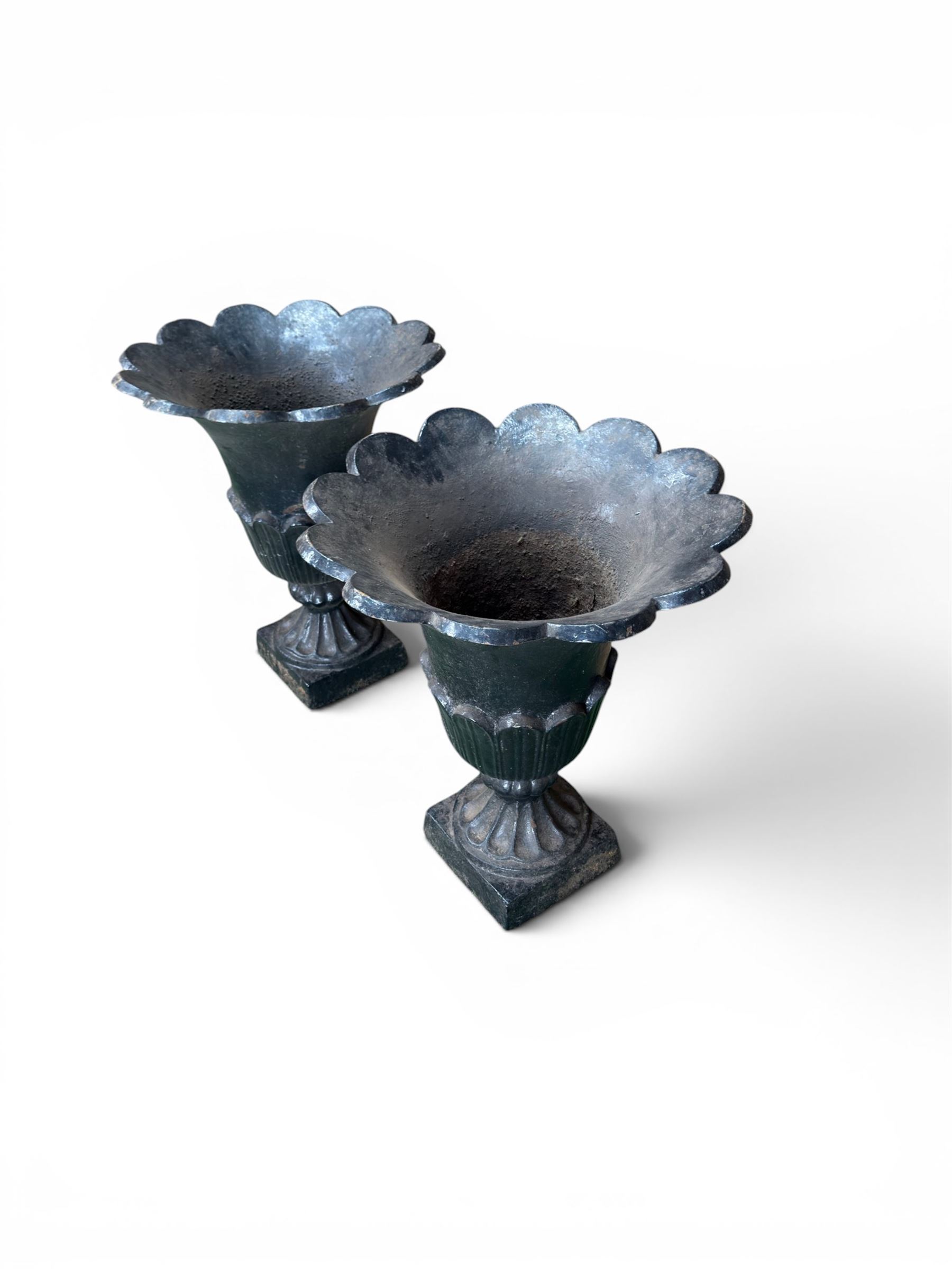 Pair of Victorian large scale cast iron garden urns, flared petal shaped rim with tapering waist, gadrooned base on square plinth, finished in black paint