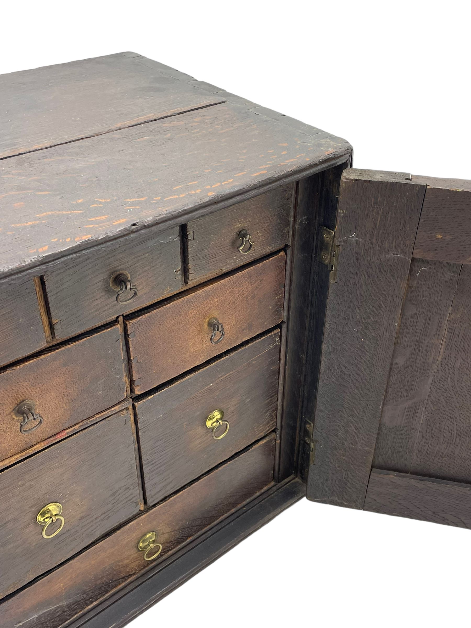 18th century oak spice cupboard, single panelled door enclosing eight drawers of various sizes, reed moulded front edges