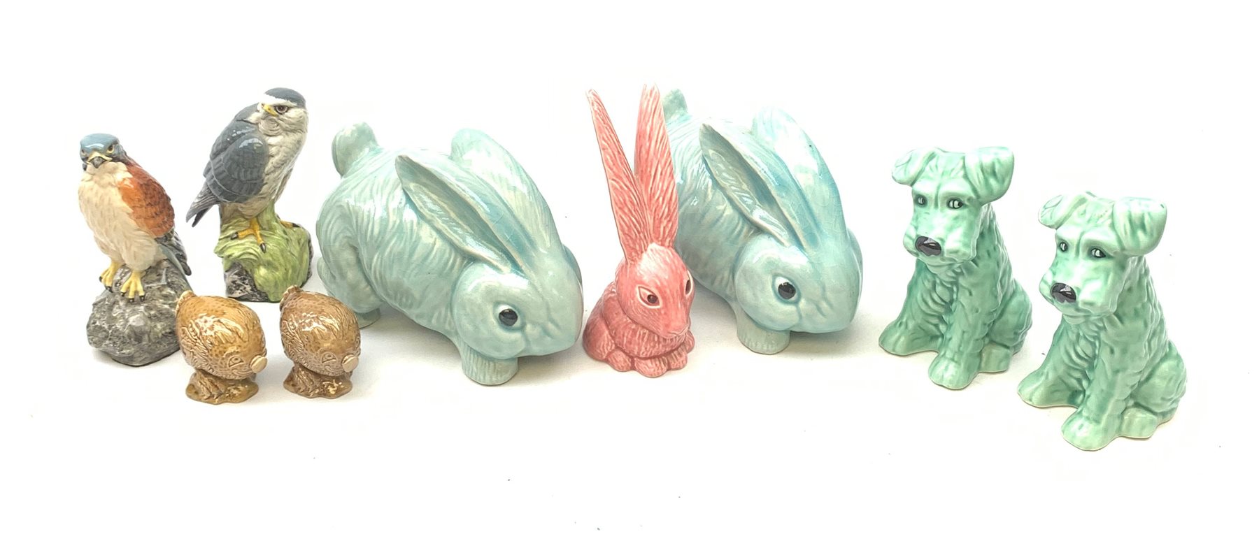 Two Sylvac Terrier dog figurines, each marked beneath and numbered 1379, a pink Sylvac rabbit, and two later Sylvac rabbits, together with two Beswick Beneagles decanters, Kestre and Merlin, and two smaller Beswick Beneagles decanters. 