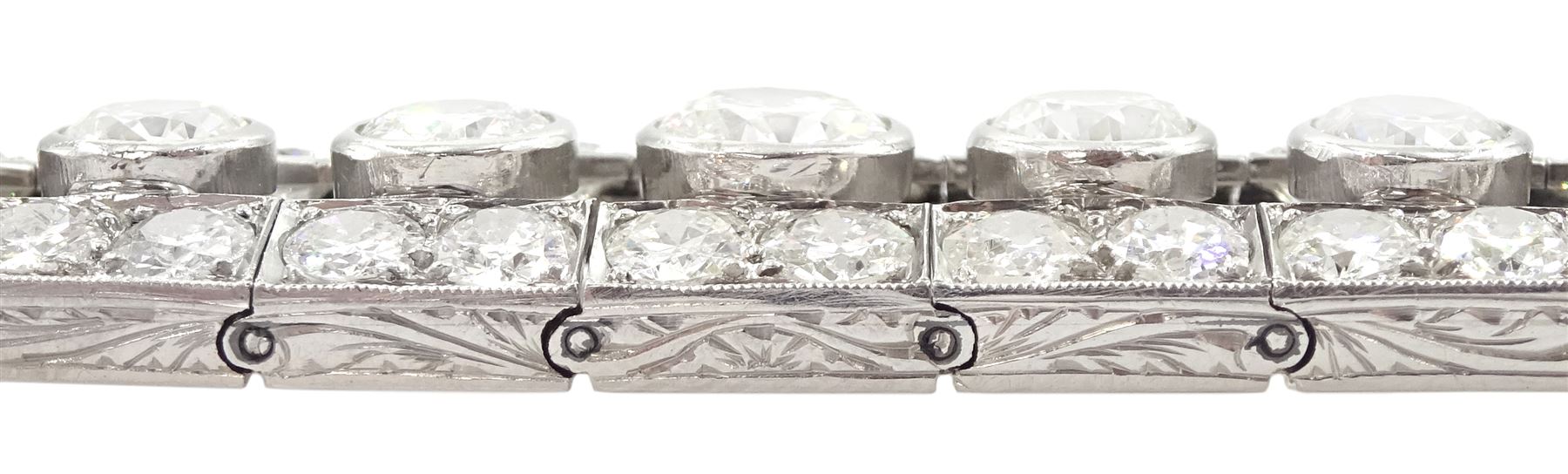Continental Art Deco platinum old cut diamond openwork bracelet, circa 1920's, twenty-two bezel set graduating diamonds of approx 9.45 carat, the principal diamond approx 0.90, with a row milgrain set diamonds either side, the clasp set with a single diamond, the bracelet sides and clasp with engraved foliate decoration, total diamond weight approx 20.60 carat