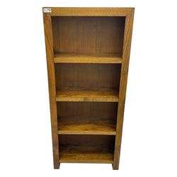 Contemporary Dakota mango wood open bookcase, rectangular form with four fixed open shelves, raised on stile supports