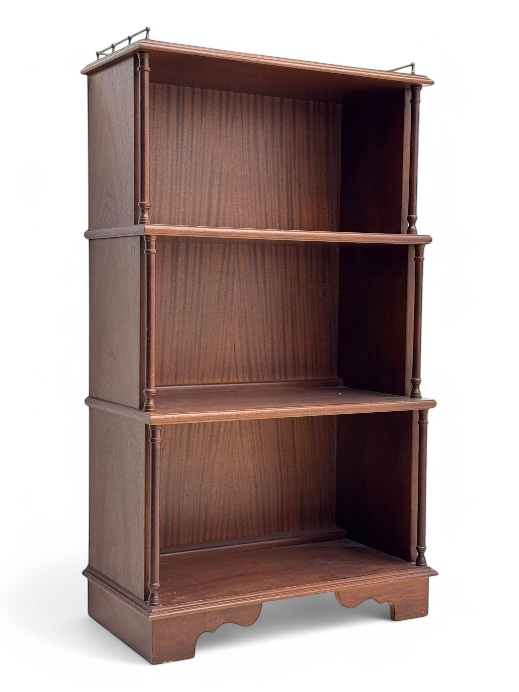 Mid-20th century mahogany open bookshelf, the rectangular top with a brass balustrade gallery, over three shelves each supported by turned column uprights, on shaped apron base