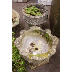  Two circular composite stone low garden urns, bodies relief decorated with roundels and leafage on square bases, D46cm, H40cm, max (2)  