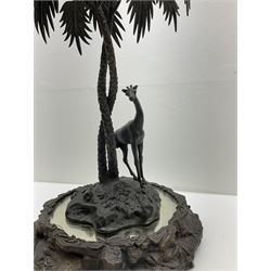 Sculpture of a giraffe under a palm tree upon a mirrored base, H48cm