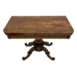 Victorian figured rosewood card table, fold-over swivel top with circular baize lining, moulded frieze with stylised flower head carving to corners, turned column with egg and dart decoration, on quadruple splayed c-scroll carved supports, with brass castors