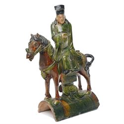 Chinese Ming dynasty Sancai Glazed Roof Tile, modelled as a dignitary on horseback, dressed in a long robe with voluminous folds, wearing an official's cap, upon a half cylinder tile, H40cm