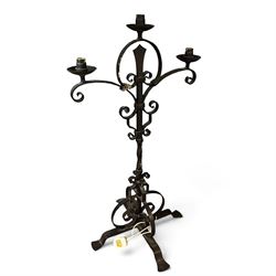 Collection of wrought iron candle stands, comprising five-light and three-light floor-standing candelabra with scrolling branches, and a pair of five-light table candelabra of naturalistic branching form