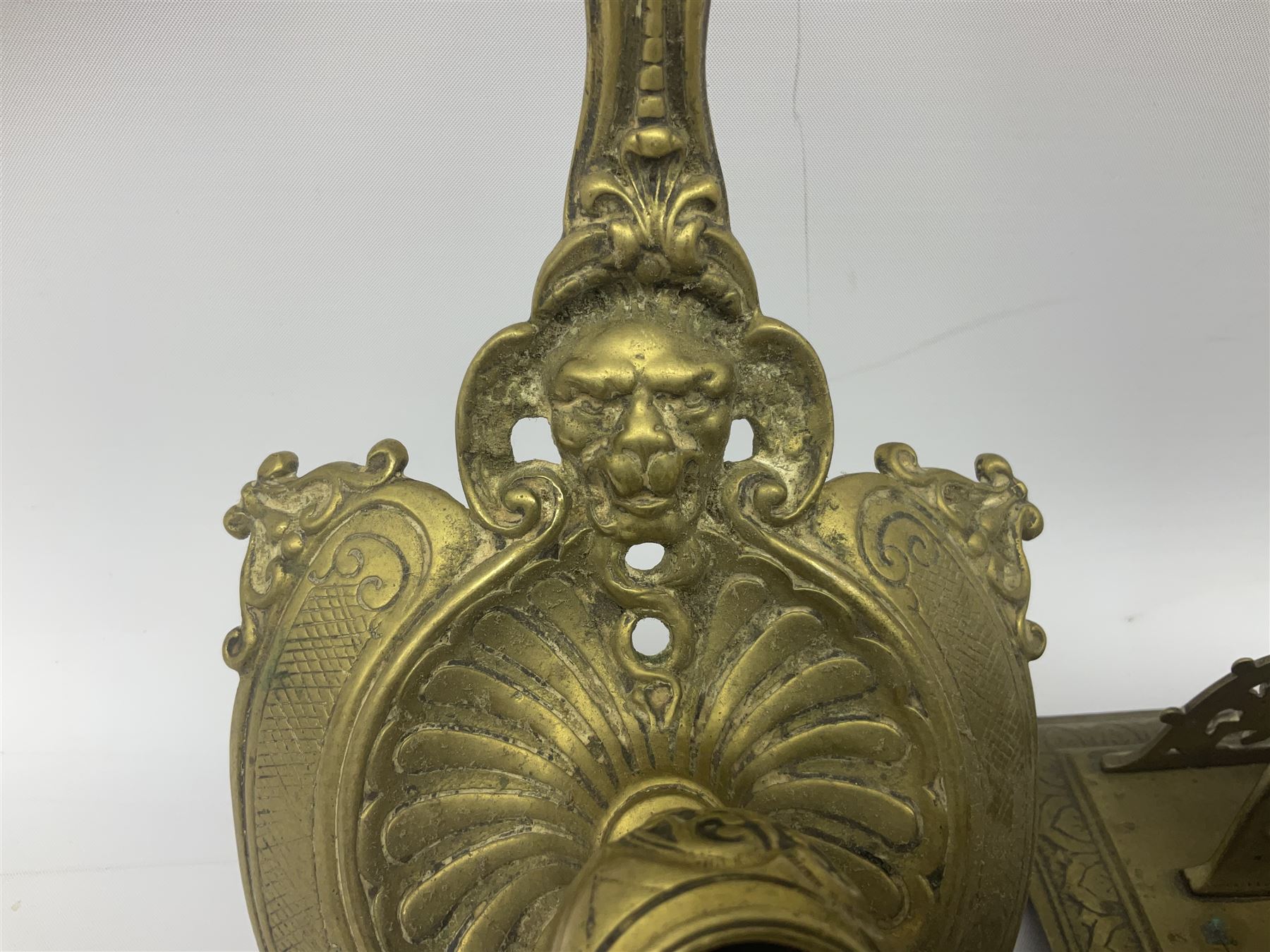 Collection of victorian and later brass desk accessories, to include a letter holder with cherub design, ink well of square form with hinged lid, brass table bell, brass casket with relief decoration, etc  