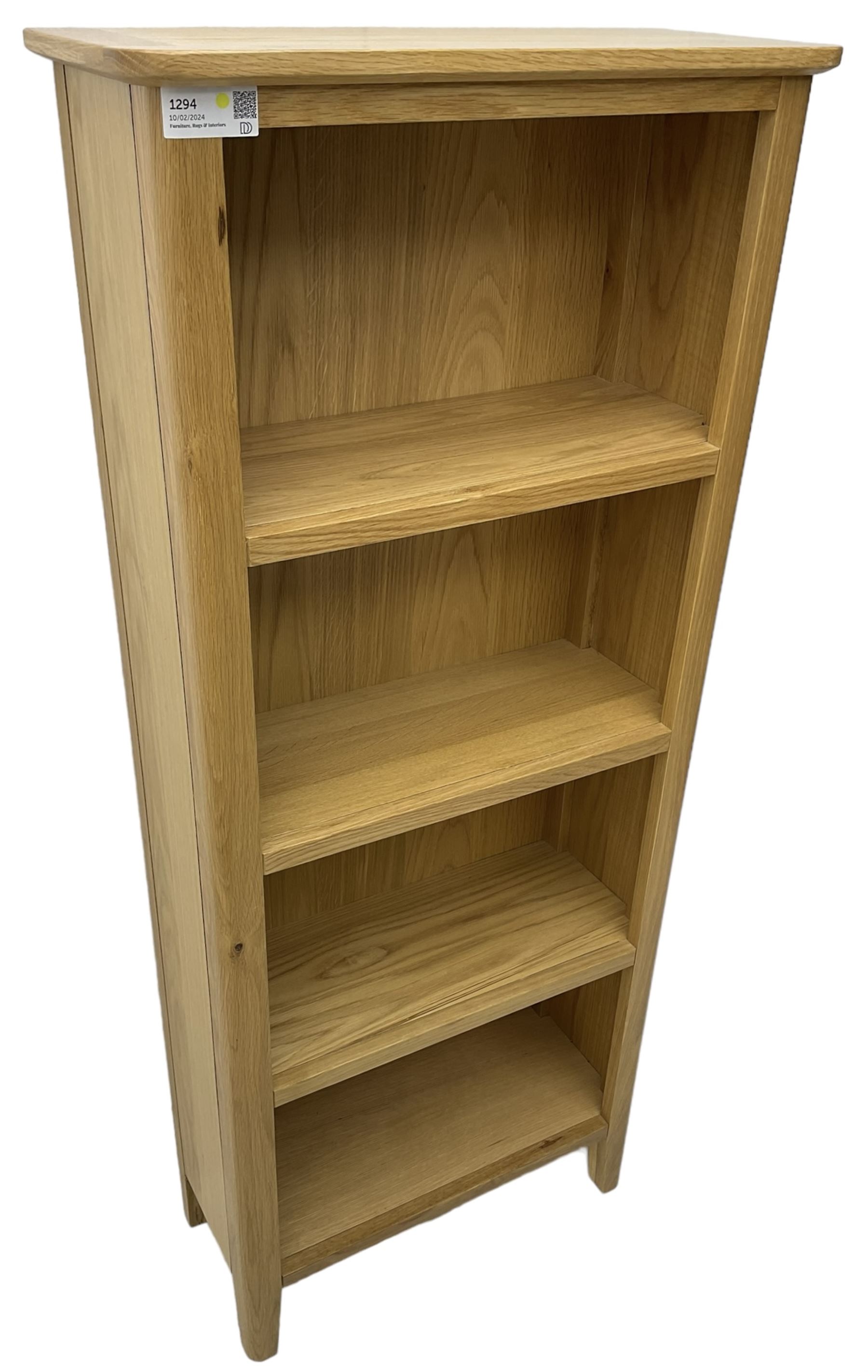 Contemporary light oak open bookcase, fitted with three shelves, on tapering supports