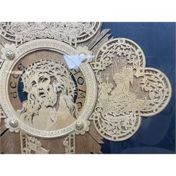 Cork carving of a religious cross depicting intricate scenes of various religious figures and motifs amongst trees and foliage, with central circular panel of Jesus Christ, in glazed frame, H95cm