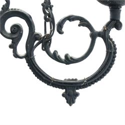 Late 19th century wrought metal hanging ceiling lamp, the ornate pierced central reservoir-form body with mounted eagle, three scrolling branches fitted with three clear glass chimney shades, suspended by decorative chains from a pierced ceiling rose