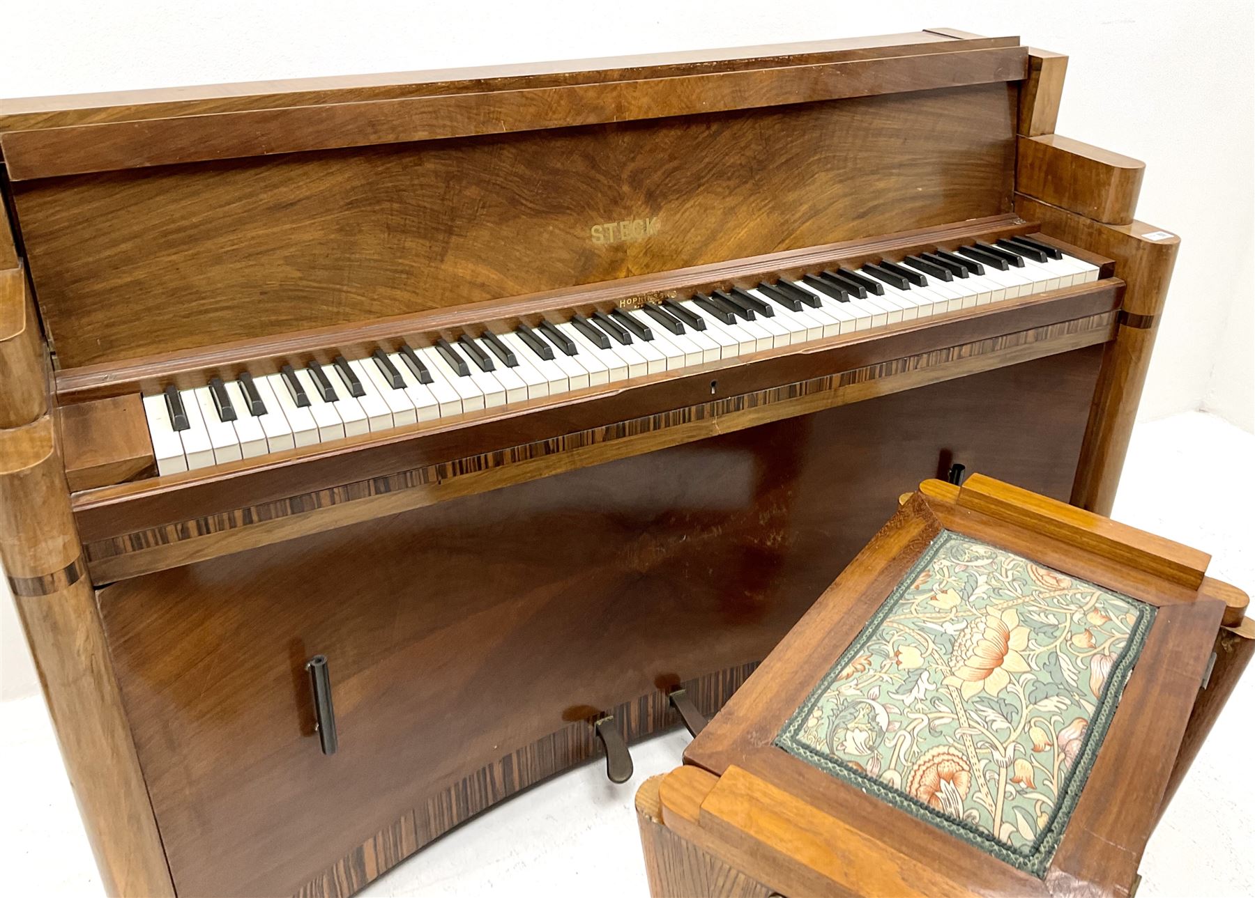 Art Deco Steck upright piano in walnut case with cross banding details and recoverable music stand (W190cm, D52cm, H97cm), together with matching style stool, lift lid seat upholstered in floral patterned fabric (W62cm, D44cm, H55cm)