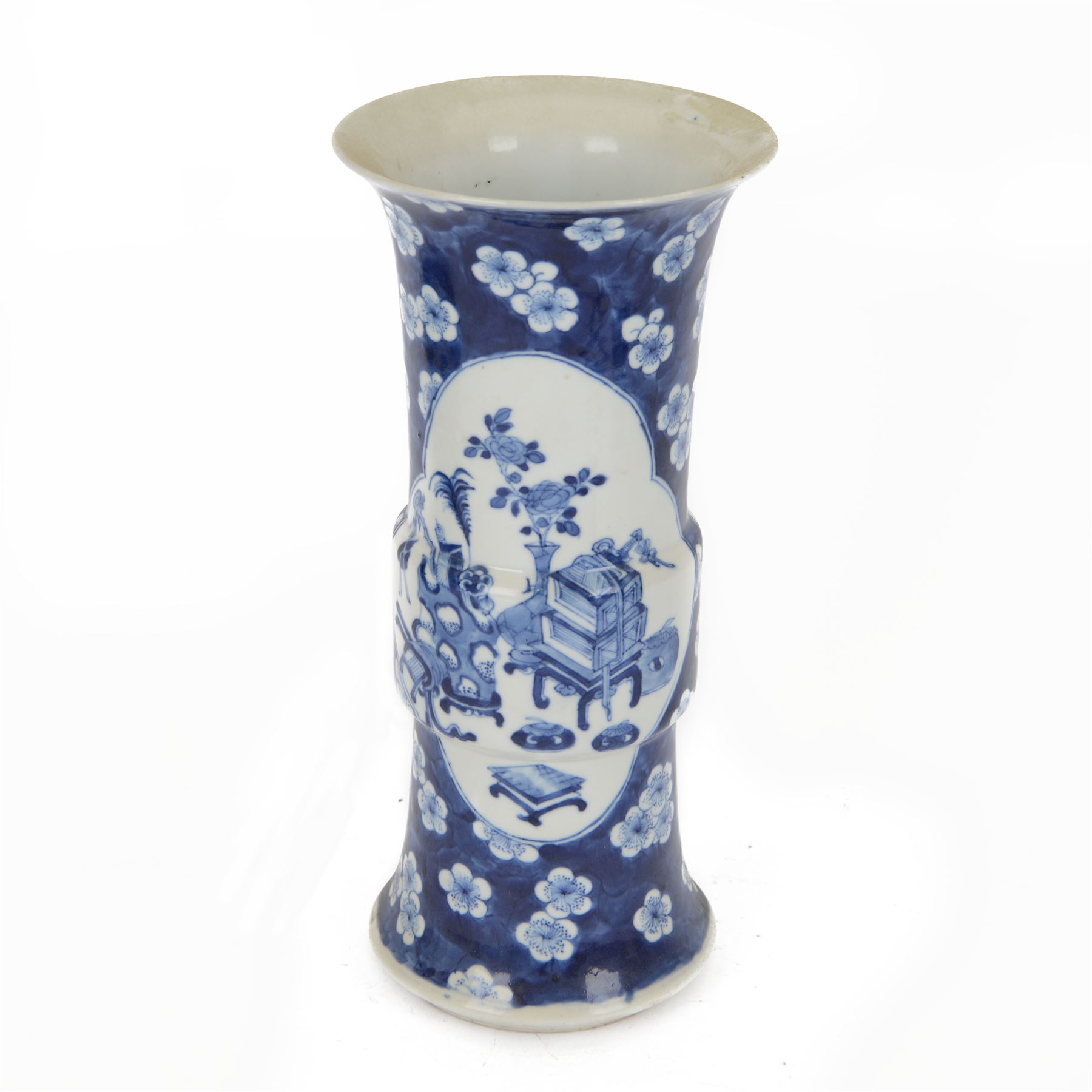 Late 19th century Chinese blue and white gu beaker vase, decorated with two lobed reserves containing precious objects, against a prunus and cracked ice ground, with apocryphal Kangxi mark beneath, H30.5cm