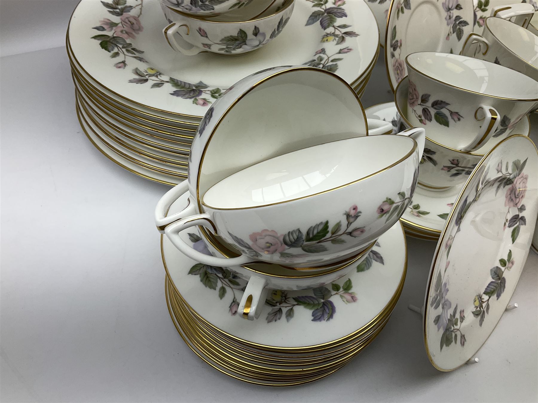 Royal Worcester June Garland pattern tea and dinner wares, comprising thirteen dinner plates, twelve dessert plates, twelve side plates, six twin handled soup bowls and six saucers, six small bowls, sauce boat and stand, thirteen teacups and fifteen saucers, open sucrier, and milk jug