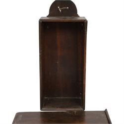 Three George III and later oak candle boxes, the first example of tapering form with shaped and pierced scroll crest, above a hinged lid, H50.5cm W18cm D13cm, the second of plain rectangular form with tapering crest, above a studded leather hinged sloped lid, H46cm W15.5cm D15.5cm, and third of plain rectangular form with demi-lune crest, with lift up front, H42.5cm W17.5cm D12cm 
