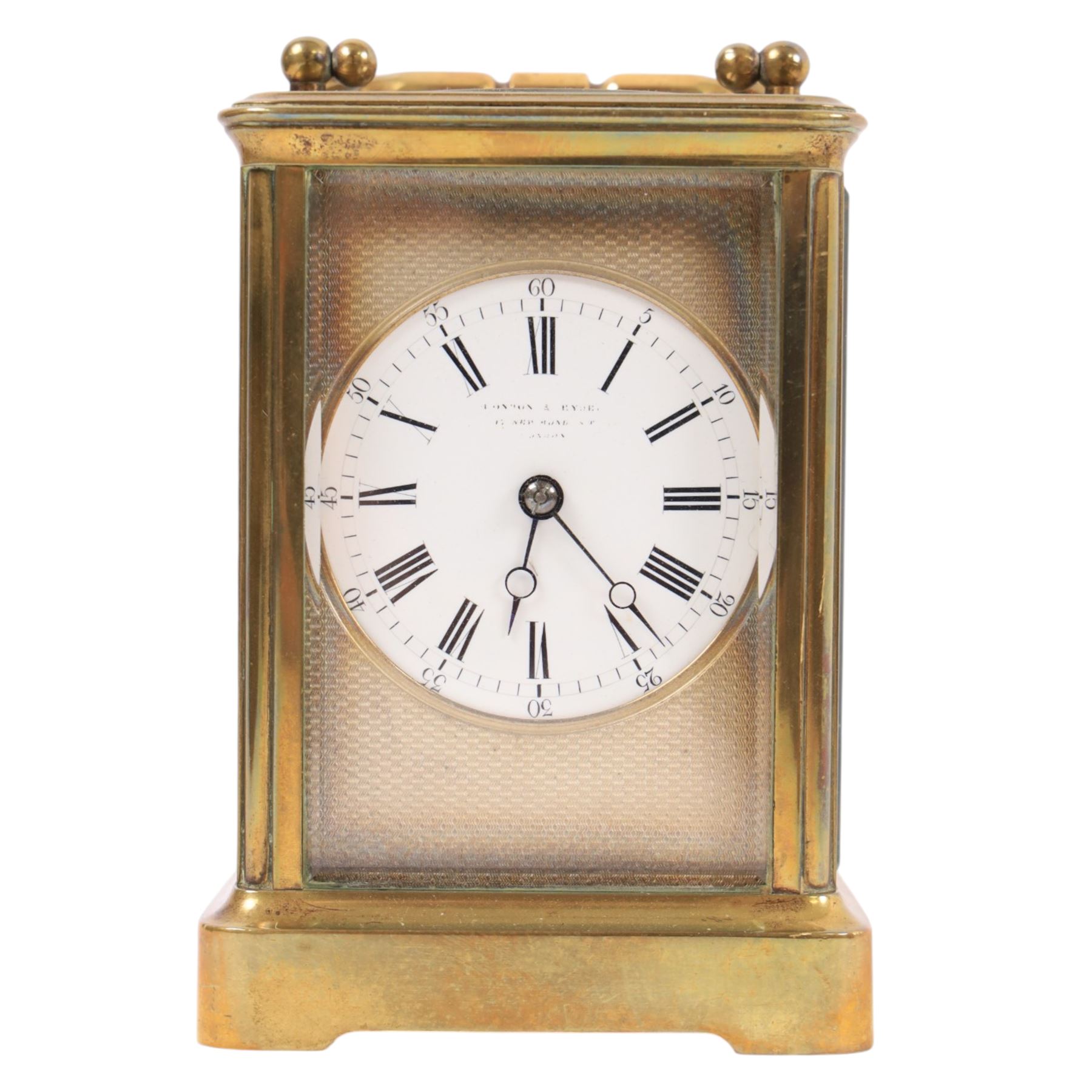 Brass carriage clock, engine turned masked dial with beveled glass sides, together with another clock 
