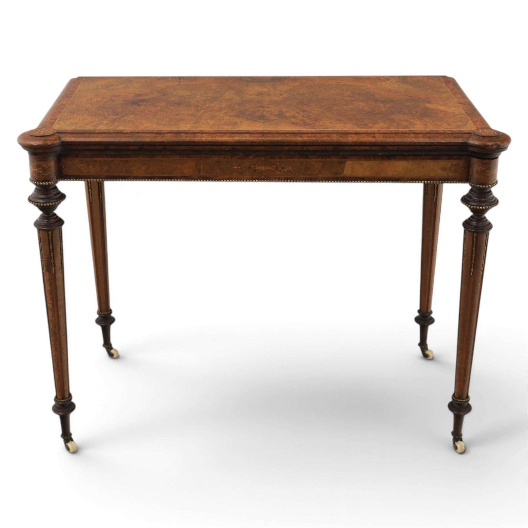 Victorian walnut card table, hinged rectangular moulded top with rounded corners and figured veneers, revealing a green baized lined interior, plain frieze with beaded lower edge, raised on ring turned tapering supports terminating in ceramic castors