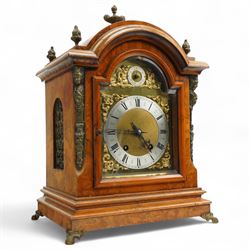 German-early 20th century mantle clock c1910, in a walnut case with a break arch top and decorative cast brass finials, brass silk backed sound frets to the sides and a glazed break-arch door flanked by a pair of cast brass caryatid, on a dee ogee moulded plinth and raised on splayed paw feet, brass dial with cast spandrels and a matted dial centre, silvered chapter ring with Roman numerals, gothic steel hands and a conforming pendulum regulation dial to the arch, two train going barrel movement with rack striking, sounding the quarters on two gongs and the hour on one, With Pendulum and key.
