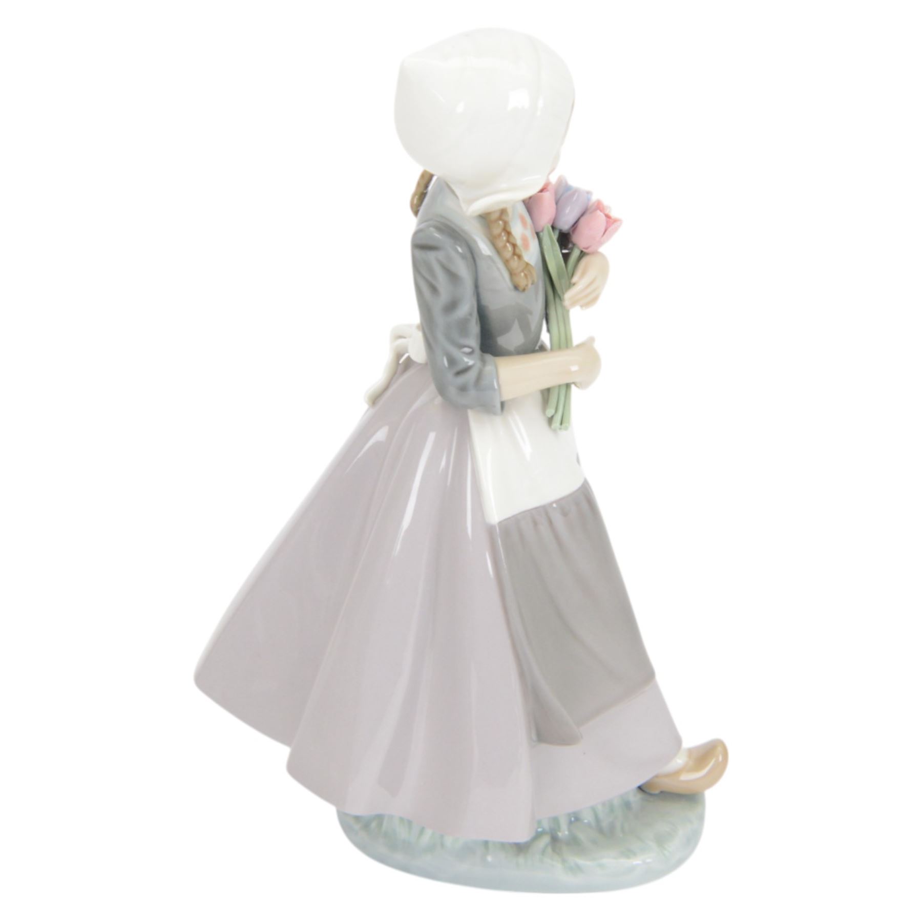 Three Lladro figures, comprising Spring Awakening 1283, Flower Harmony 1418 and Dutch girl with Tulips 5065