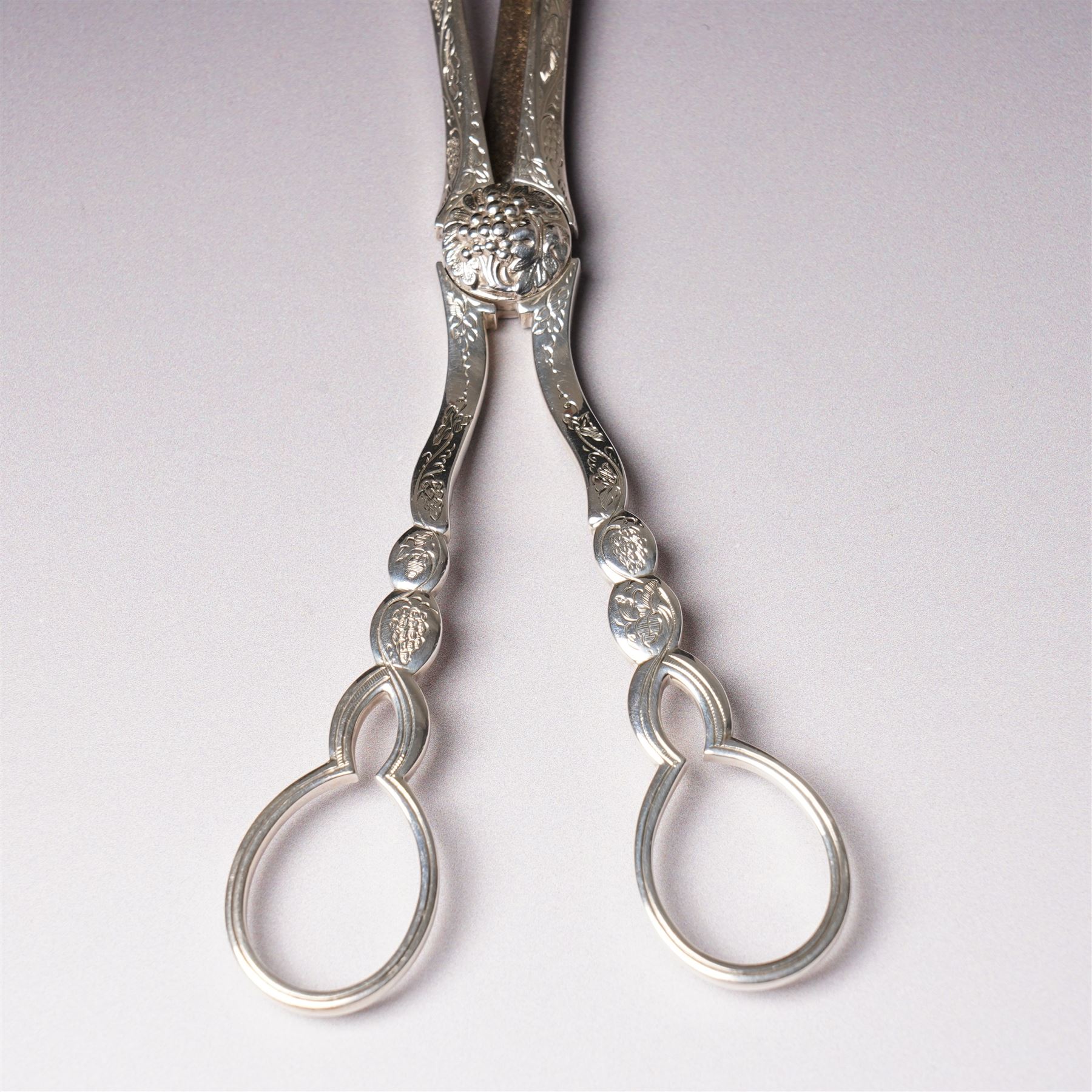 Pair of Victorian silver grape scissors with engraved decoration Birmingham 1860 Maker probably John Gilbert and a small silver sauce boat with crimped rim and C scroll handle Birmingham 1905 Maker Thomas Hayes (2)  