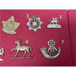 Forty glengarry and cap badges and shoulder titles including Gordon Highlanders, Canada and Canadian Field Artillery, New Zealand Field Artillery and Rifle Regiment, Shropshire Light Infantry, 14th/20th Kings Hussars, 17th Lancers, Northamptonshire Yeomanry, Royal Lincolnshire, Special Air Service, 19th Alexandra P.W.O. Hussars etc; mounted on two boards for display (2)