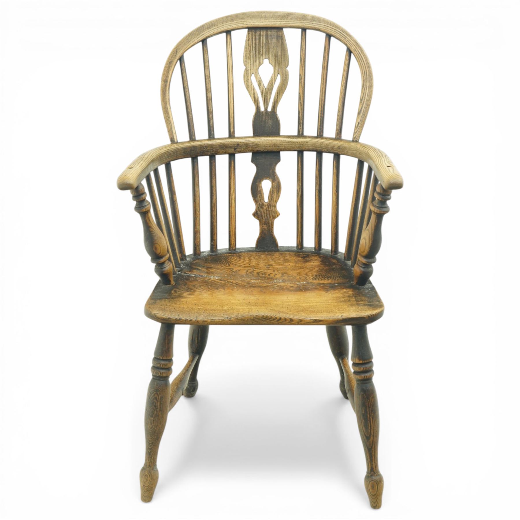 19th century low back elm Windsor armchair, hooped back with pierced central splat and radiating spindles, shaped arm bow over saddle seat, on turned supports