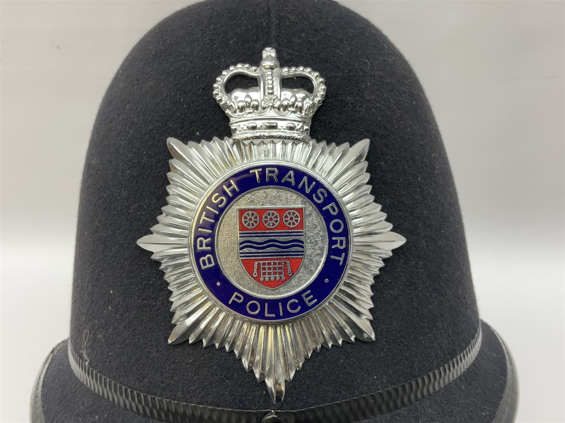 British Transport Police Custodian helmet with Queen's Crown plate; Hiatt & Co ebonised hardwood patrol truncheon; and pair of Hiatts 1960 hand-cuffs (3)