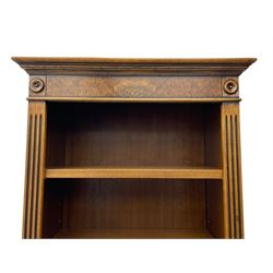 Georgian design walnut open bookcase, projecting cornice over figured banded frieze flanked by roundels, fitted with six adjustable shelves with flanking fluted uprights, on skirted base