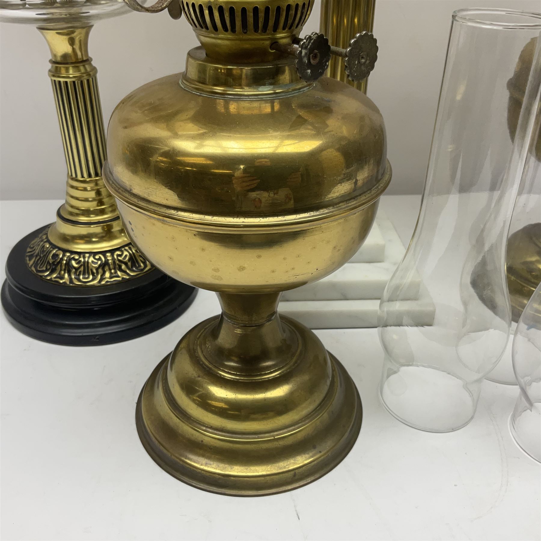 Brass Corinthian column oil lamp, upon stepped marble base, together three other brass table lamps, tallest H68cm