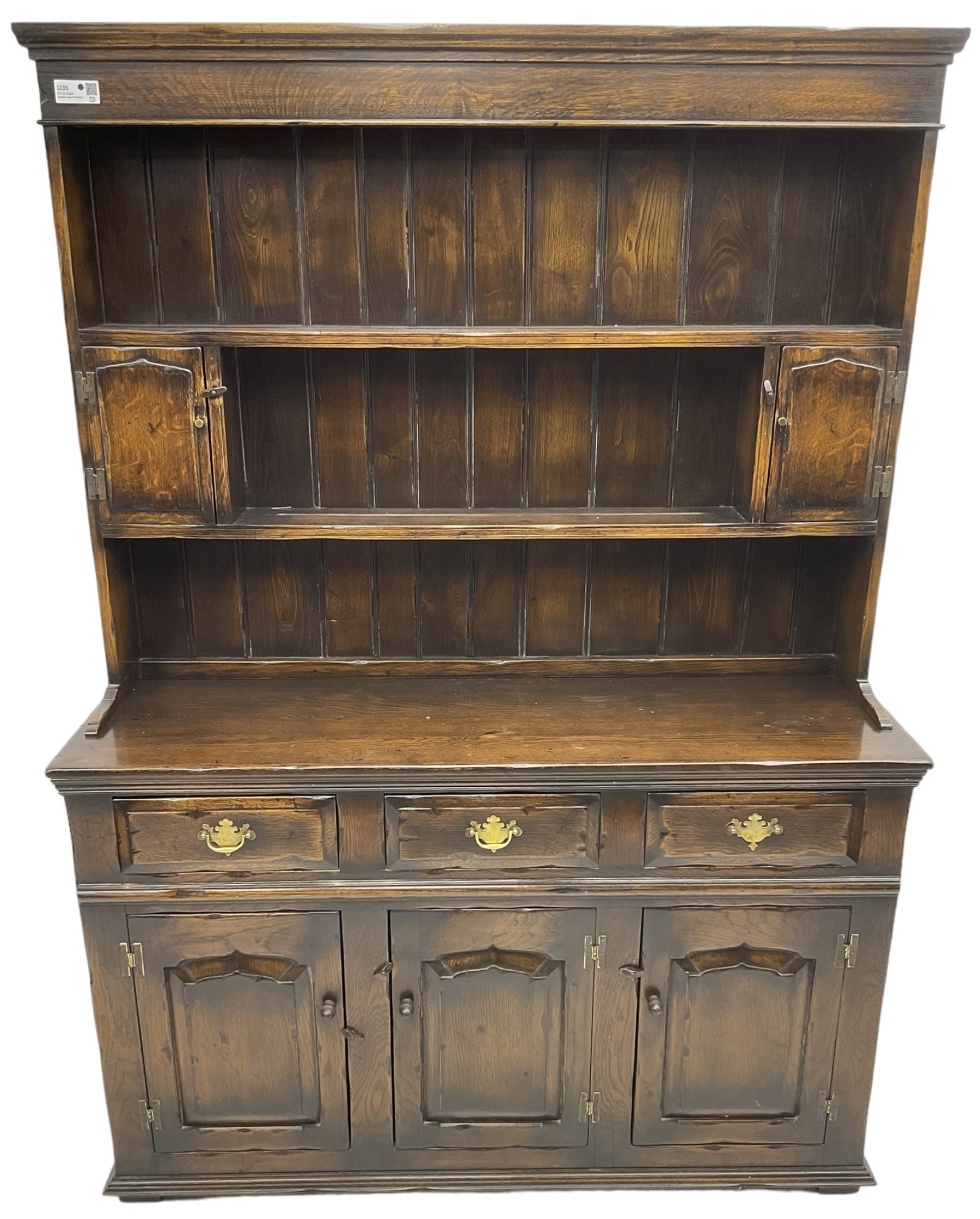 Georgian design oak dresser, the two-tier plate rack with two flanking spice cupboards, the base fitted with three drawers over three arched fielded panelled cupboards, lower moulded edge on block feet