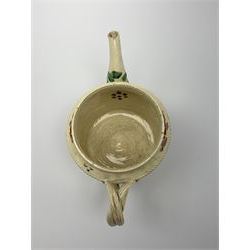 18th century creamware teapot, probably Leeds, with reeded entwined handle and floral finial to the cover, the body with hand painted polychrome decoration of figure to one side, and floral spray to the other, collectors paper label beneath inscribed Leeds Pottery, H11.5cm