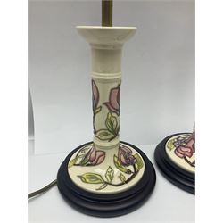 Pair of Moorcroft table lamps of candlestick form in magnolia pattern, with Moorcroft shades, H50cm 
