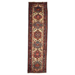Caucasian Shirvan hand-knotted runner, ivory field decorated with a vertical sequence of b...